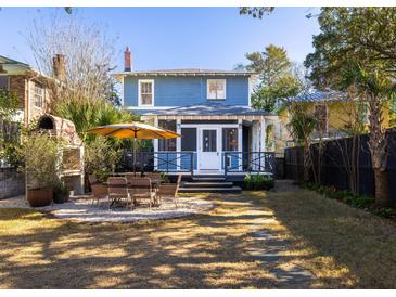 Beautiful backyard with an outdoor kitchen, dining area, and a screened-in porch at 1153 King St, Charleston, SC 29403