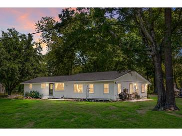 Charming single-story home featuring a well-maintained lawn and large, mature trees at 1192 Church Of God Rd, Bonneau, SC 29431