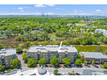 Stunning aerial view of property showcasing mature trees, lakes, and manicured landscaping on a sunny day at 125 Pier View St # 405, Daniel Island, SC 29492
