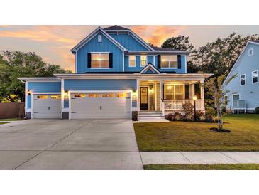 Charming two-story home features a three-car garage, a cozy front porch, and a beautifully landscaped front yard at 1511 Hopkins Ln, Mount Pleasant, SC 29466