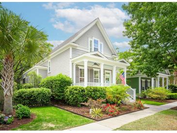 Charming two-story home with a welcoming front porch, manicured landscaping, and American flag at 1629 Ware Bottom Ln, Mount Pleasant, SC 29464
