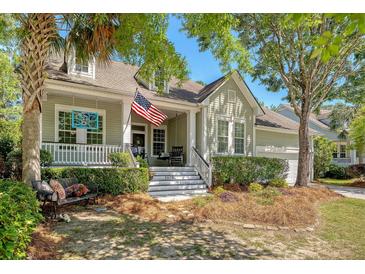 Charming home with a welcoming front porch, rocking chairs, and an American flag at 1678 William Hapton Way, Mount Pleasant, SC 29466