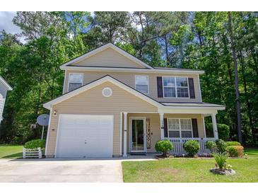 Charming two-story home with a well-manicured lawn, attached garage, and inviting front porch at 206 Trickle Dr, Summerville, SC 29483