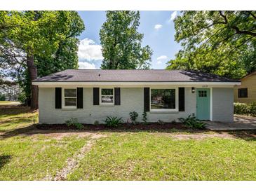 Charming one-story home with a teal door and black shutters, surrounded by lush trees at 2219 Eagle Dr, North Charleston, SC 29406