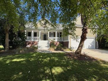 Charming home with a well-manicured lawn, mature trees, and a welcoming front porch at 255 Oak Point Landing Dr, Mount Pleasant, SC 29464