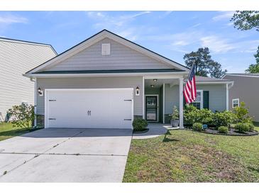 Charming single-story home with a two-car garage, well-manicured lawn and an American flag at 2809 Conservancy Ln, Charleston, SC 29414