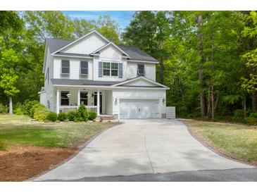 Beautiful two-story white home with a well-manicured lawn and a long driveway leading to an attached two-car garage at 3361 Olivia Marie Ln, Johns Island, SC 29455