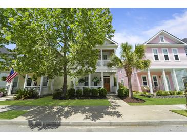 Charming multi-story homes with inviting front porches, manicured lawns and attractive landscaping creating a vibrant neighborhood street view at 404 Forsythia Ave, Summerville, SC 29483