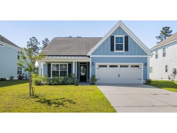 Charming blue home featuring a two-car garage and well-manicured front lawn at 603 Yellow Leaf Ln, Summerville, SC 29486