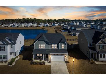 Beautiful home exterior with a lake view, complemented by lush greenery and situated in a serene neighborhood at 705 Squire Pope Rd, Summerville, SC 29486