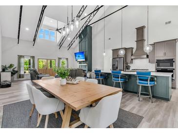 Open-concept living room with modern kitchen, dining area, high ceilings, and large windows offering plenty of natural light at 733 Oakridge View Trl, Ridgeville, SC 29472