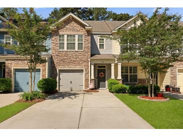 Charming townhome with a stone facade, inviting front porch, and well-manicured landscaping at 849 Bibury Ct, Charleston, SC 29414