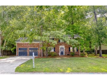 Charming brick home with an attached two-car garage and lush greenery in a well-maintained front yard at 103 Sylvan Ter, Summerville, SC 29485