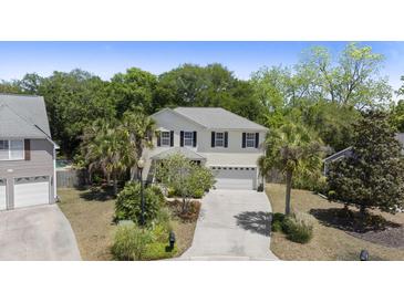 Traditional two-story home with neutral siding, black shutters, palm trees, and a well-manicured lawn at 1087 Clearspring Dr, Charleston, SC 29412