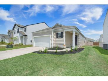 Charming one-story home with well-maintained lawn, garden bed, and a one car attached garage at 110 Green Passage Ln, Summerville, SC 29486