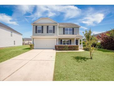 Charming two-story home with a well-manicured lawn, attached garage, and inviting front porch, perfect for suburban living at 1130 Moss Grove Dr, Moncks Corner, SC 29461