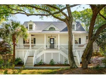 Charming two-story home with a classic front porch and lush, mature trees at 1483 Harborsun Dr, Charleston, SC 29412