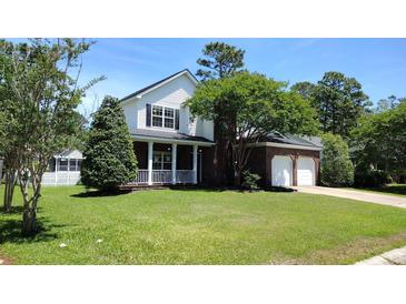 Charming two-story home with brick accents, a covered porch, and a well-manicured lawn at 15 Muirfield Village Ct, Summerville, SC 29483