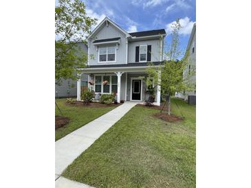 Charming two-story home featuring a welcoming front porch and beautifully landscaped front yard with vibrant green grass at 203 O'Malley Dr, Summerville, SC 29483