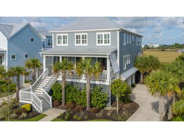 Charming two-story home featuring a metal roof, palm trees, and a welcoming front porch at 2522 Waverly St, Charleston, SC 29492
