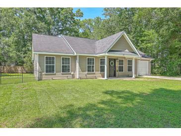 Charming home boasts a manicured lawn, neutral siding, and a welcoming entrance, complete with a black door at 333 Price St, Goose Creek, SC 29445