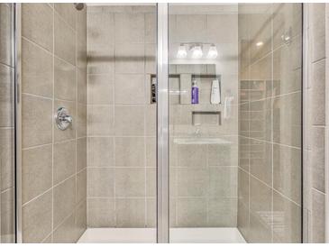 Tiled shower with glass door and built in shelves to hold soap and shampoo at 404 Snowy Plover Ln, Summerville, SC 29486
