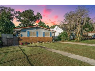 Charming single-story home with a brick foundation, blue shutters, and lush green lawn at dusk at 4515 Holmes Ave, North Charleston, SC 29405
