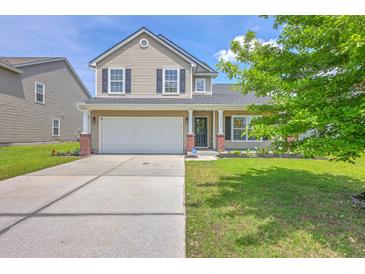 Charming two-story home with a well-manicured lawn, a two-car garage, and a welcoming front porch at 5032 Ballantine Dr, Summerville, SC 29485