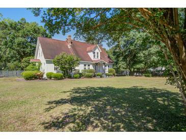 Charming home with a well-manicured lawn and mature trees offers classic curb appeal at 5615 Highway 165, Ravenel, SC 29470