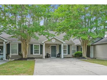 Charming home featuring a well-maintained lawn, mature trees, and welcoming curb appeal at 7999 Vermont Rd, North Charleston, SC 29418