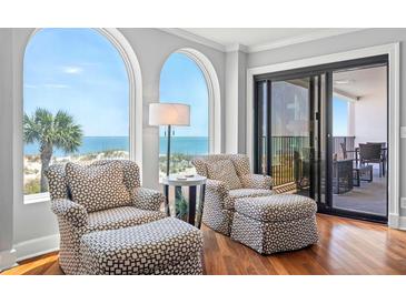 Bright sitting area featuring stylish chairs, ocean views, and access to a private balcony at 9002 Palmetto Dr # 119, Isle of Palms, SC 29451