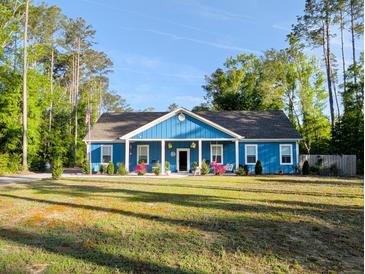 Charming blue single-story home with a welcoming front porch and well-maintained yard at 1044 Towhee Ln, McClellanville, SC 29458