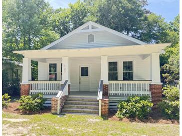 Charming white craftsman-style home with a welcoming front porch and manicured landscaping at 107 Tracy St, Walterboro, SC 29488