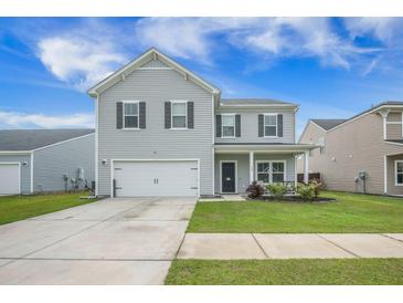 Charming two-story home with gray siding, attached garage, landscaped yard, and inviting front porch, perfect for relaxing outdoors at 134 Lucca Dr, Summerville, SC 29486