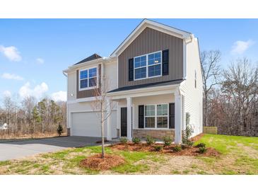 Charming two-story home with a two car garage, stone accents, and a manicured lawn at 1816 Casein St, Summerville, SC 29483