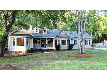 Charming one-story home with a well-manicured lawn and lush landscaping in a serene, tree-filled setting at 213 Factors Walk, Summerville, SC 29485