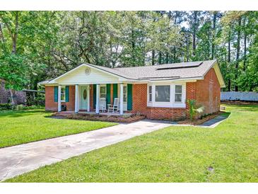 Charming brick home featuring a well-manicured lawn, inviting front porch, and vibrant green shutters at 403 Forest Cir, Summerville, SC 29483