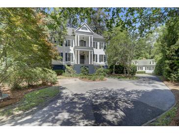 Two-story home featuring a double balcony, manicured landscaping, and circular driveway for curb appeal at 418 W Carolina Ave, Summerville, SC 29483