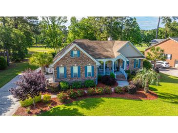 Charming brick home with blue shutters, inviting front porch, and lush landscaping, surrounded by mature trees at 1187 Out Of Bounds Dr, Summerville, SC 29485