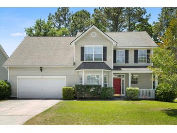 Charming two-story home boasts well-maintained landscaping, a red door, and a two-car garage at 1223 Creek Stone Way, Hanahan, SC 29410