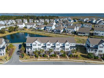 Gorgeous aerial view of a neighborhood with townhomes, a pond, and lush greenery, offering serene waterfront living at 1614 Prince Edward St, Mount Pleasant, SC 29466