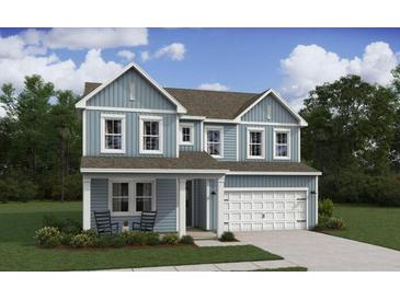 Charming two-story home with a light blue exterior, a front porch, and a two-car garage, surrounded by a lush green lawn at 2038 Mcguire Ln # 010, Hollywood, SC 29449