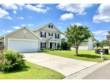 Charming two-story home featuring a manicured lawn and attached two-car garage at 303 Seneca River Dr, Summerville, SC 29485