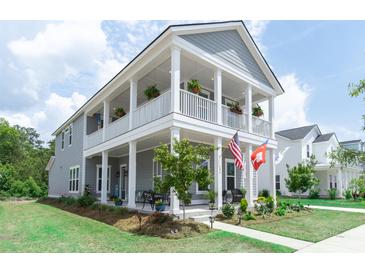 Charming two-story home featuring a spacious porch, landscaped yard, and inviting curb appeal at 397 Woodgate Way, Summerville, SC 29485
