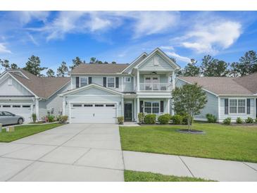 Charming two-story home with a well-manicured lawn, a two-car garage, and a welcoming front porch at 419 Whispering Breeze Ln, Summerville, SC 29486