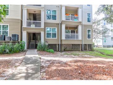 Three-story condo building showcasing balconies and well-maintained landscaping at 700 Daniel Ellis Dr # 4107, Charleston, SC 29412