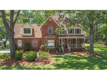 Charming two-story brick home with well-manicured lawn, mature trees and inviting front porch at 8661 Laurel Grove Ln, North Charleston, SC 29420