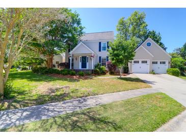 Charming two-story home with attached garage and a well-manicured front yard on a sunny day at 1001 Foxcroft Rd, James Island, SC 29412