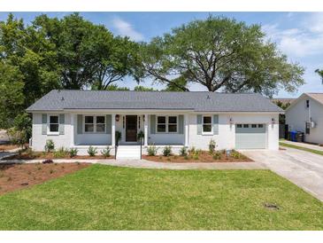 Charming, single-story home boasts a well-manicured lawn and an attached garage with a beautiful driveway at 1199 Island View Dr, Mount Pleasant, SC 29464