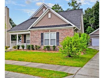 Charming single-Gathering home featuring a brick facade, well-manicured lawn, and a detached garage at 136 Pavilion St, Summerville, SC 29483
